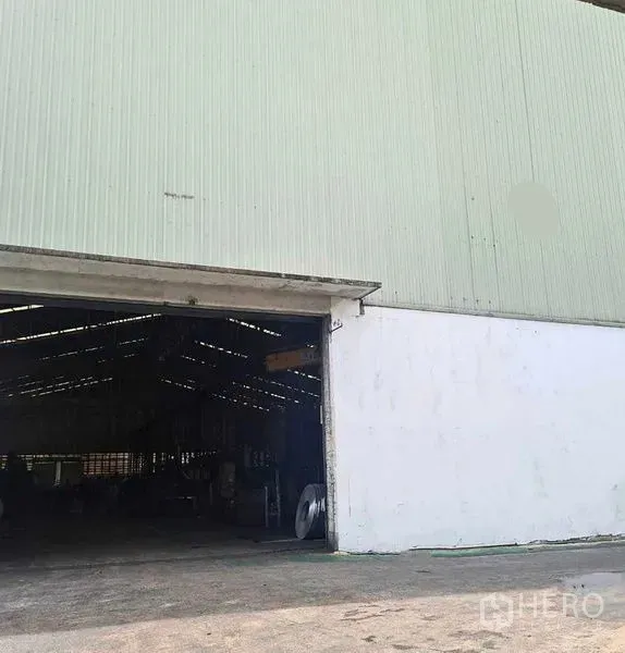 Warehouse for rent in Phra Pradaeng, Samut Prakan - Side exterior wall with corrugated cladding and an open loading bay