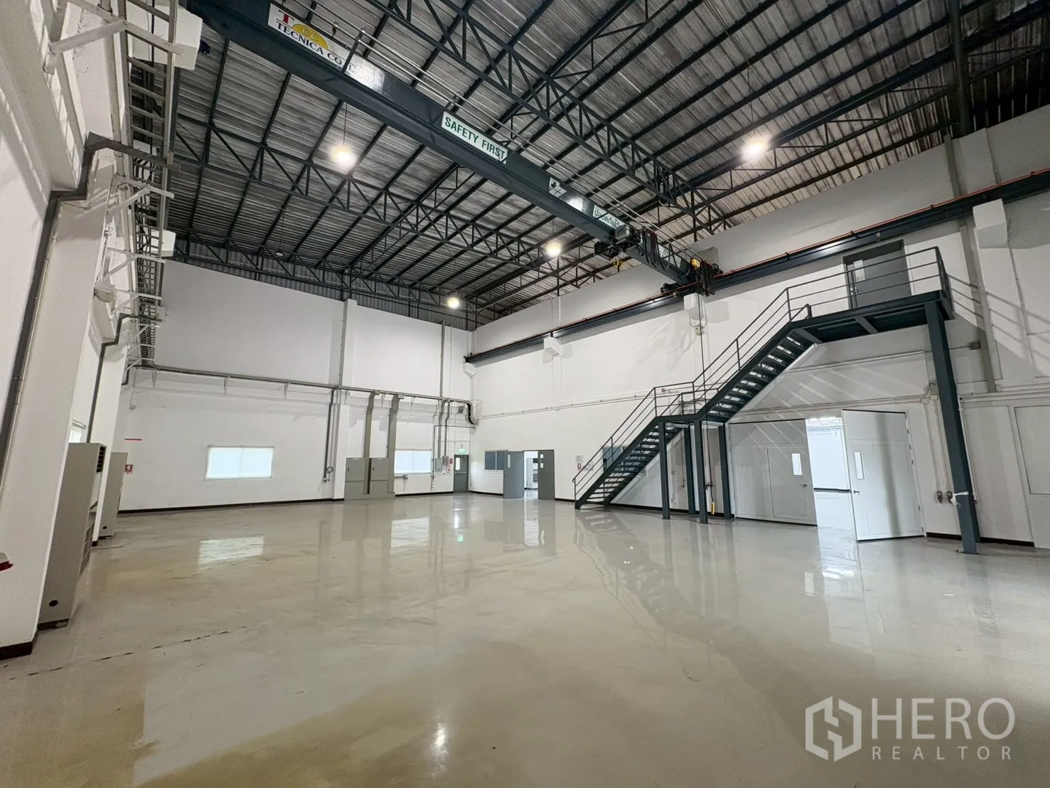 Factory for sale in Bang Bo, Samut Prakan - Open workshop with overhead crane, steel staircase and bright lighting.