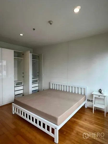 公寓 出租在Ratchathewi, Bangkok - 主卧配白色床架、衣柜与温润木地板。