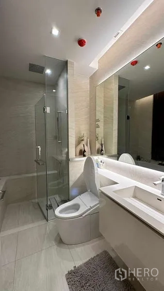 Condominium for sale - Contemporary bathroom featuring glass shower, smart toilet and long vanity counter.