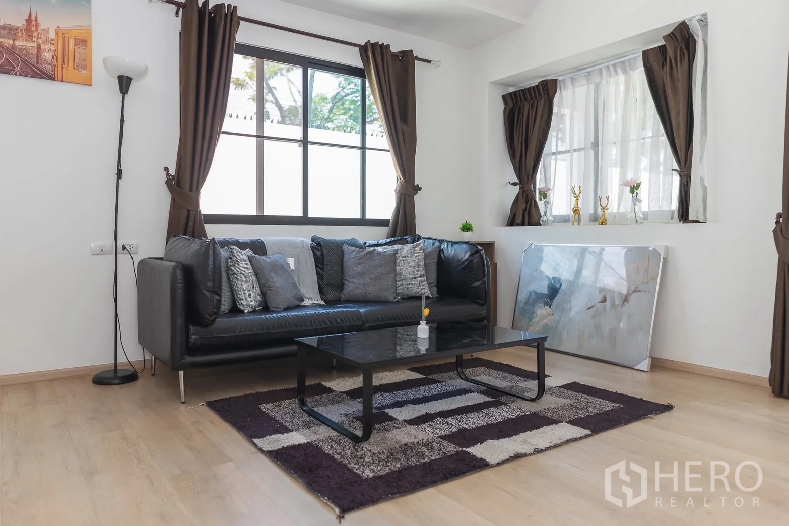 Townhouse for rent in Bang Phli, Samut Prakan - Living space with black leather sofa, coffee table, and accent rug.