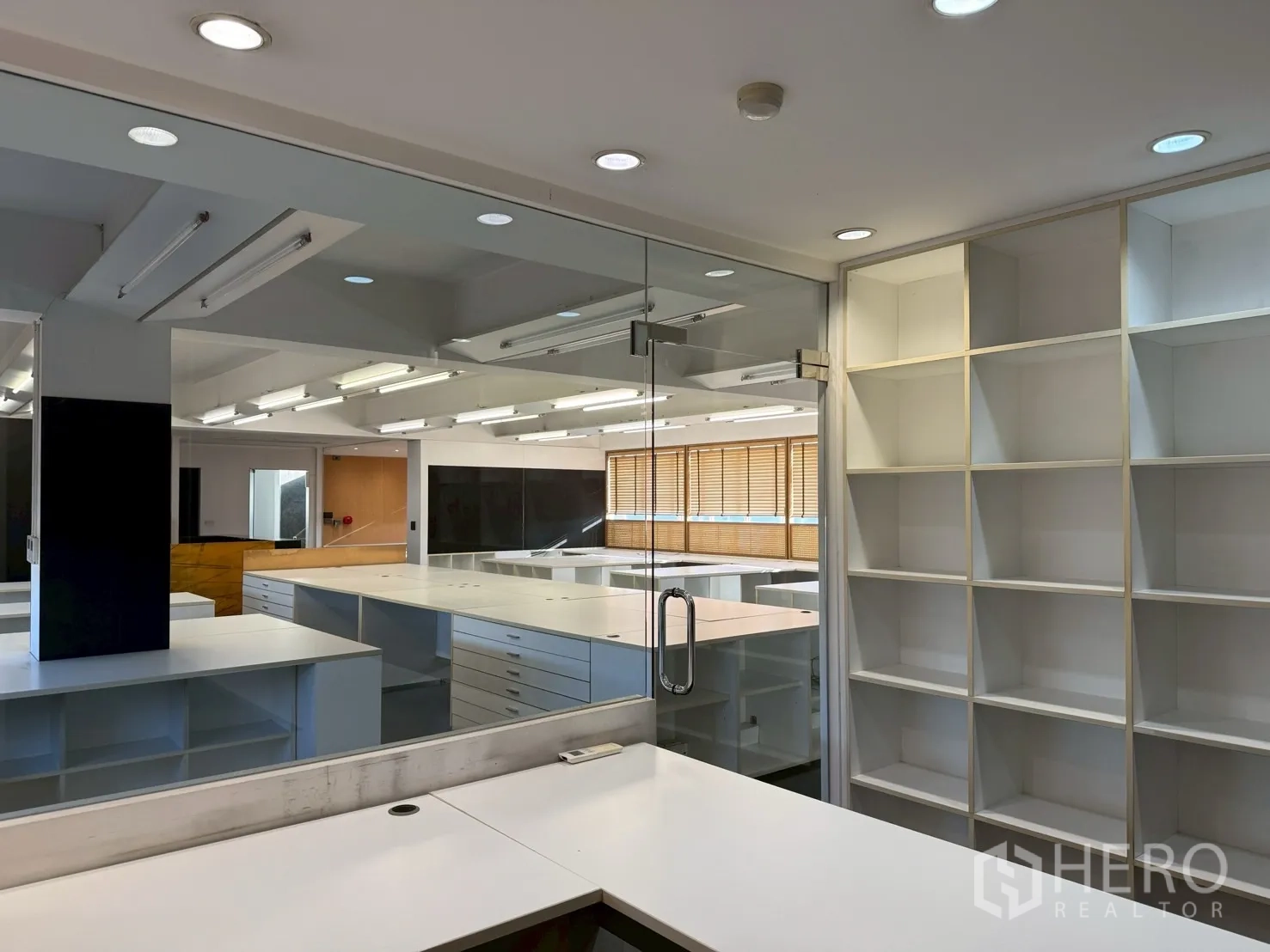 Office Space for rent in Huai Khwang, Bangkok - Glass-walled meeting room with sliding door, recessed lighting and built-in shelves.
