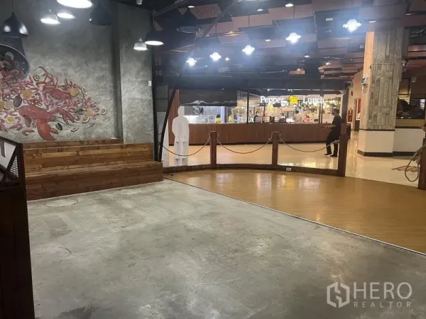 零售空间 出租在Khlong Toei, Bangkok - 宽敞开放空间，带木质台阶和绳索围栏，面向商场步行区与餐饮摊位。