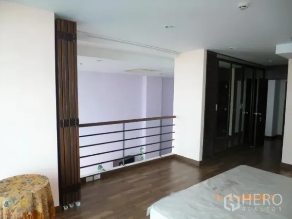 คอนโด ให้เช่าในPathum Wan, Bangkok - โซนชั้นลอยสไตล์โลฟต์ พื้นไม้ ราวระเบียงมองลงสู่พื้นที่นั่งเล่นดับเบิลโวลุ่ม พร้อมตู้เสื้อผ้าบิวท์อิน