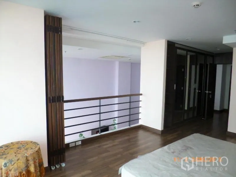 คอนโด ให้เช่าในPathum Wan, Bangkok - โซนชั้นลอยสไตล์โลฟต์ พื้นไม้ ราวระเบียงมองลงสู่พื้นที่นั่งเล่นดับเบิลโวลุ่ม พร้อมตู้เสื้อผ้าบิวท์อิน