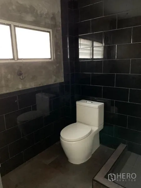 อาคารพาณิชย์ ขายในHuai Khwang, Bangkok - ห้องน้ำกระเบื้องสีดำ หน้าต่างกระจกฝ้า และโถสุขภัณฑ์สีขาว