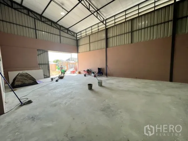 Warehouse for rent in Bang Bua Thong, Nonthaburi - Open storage bay with wide sliding door and polished concrete floor inside the warehouse.