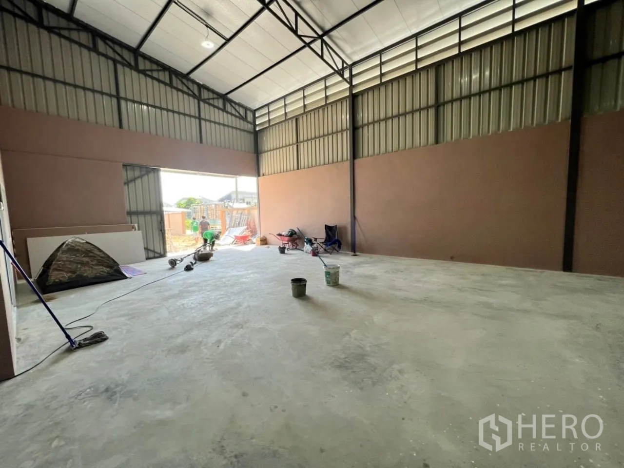 Warehouse for rent in Bang Bua Thong, Nonthaburi - Open storage bay with wide sliding door and polished concrete floor inside the warehouse.