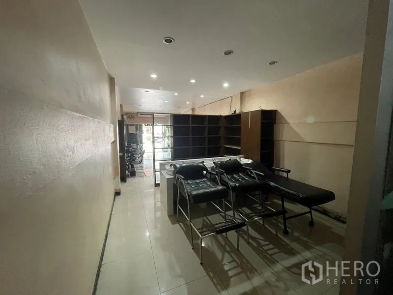 店屋 出租在Phra Khanong, Bangkok - 后部区域带货架与理疗床，顶灯照明。