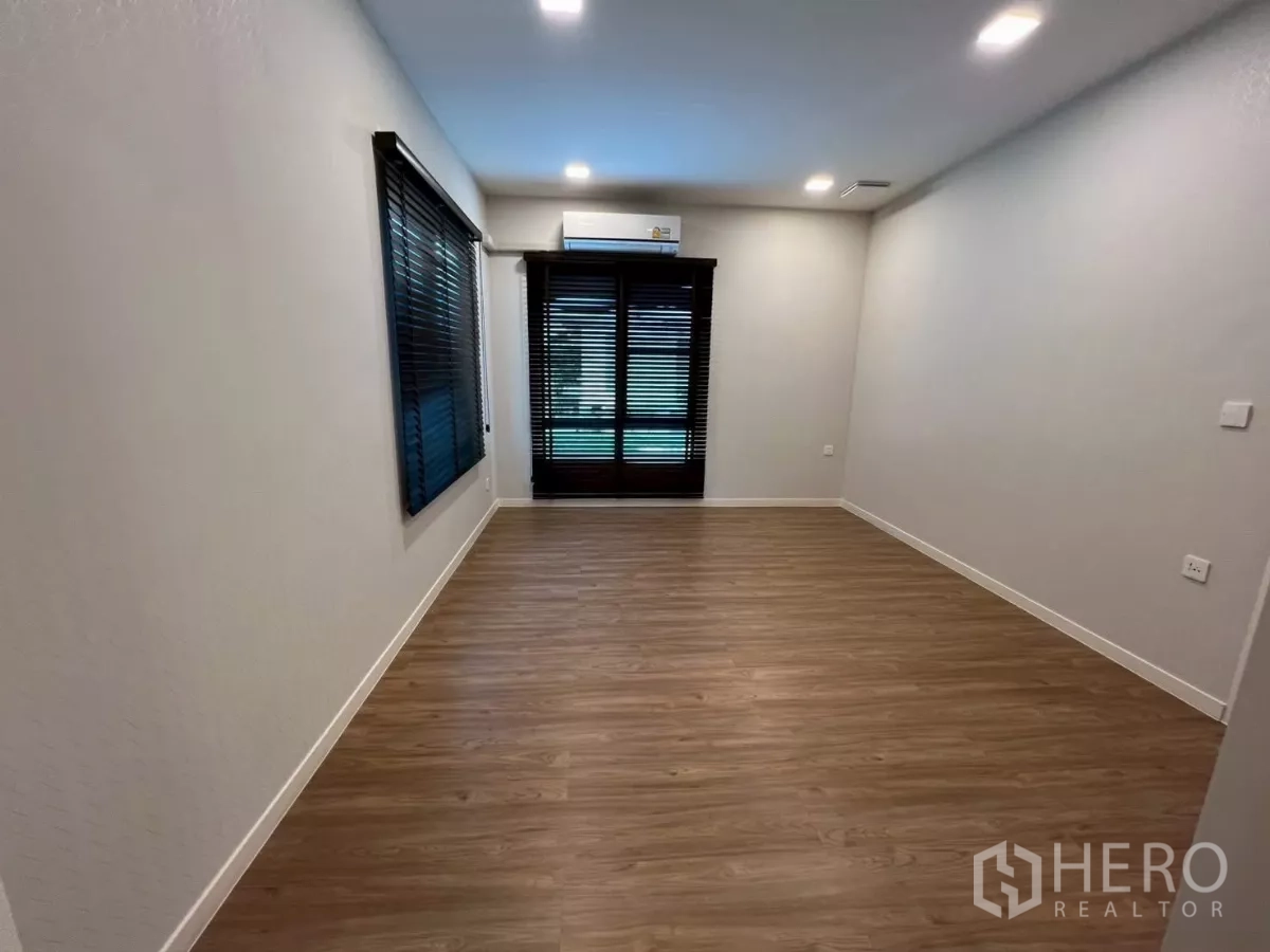 Detached House for rent in Samut Prakan - Ground-floor multipurpose room with wood flooring and window blinds.