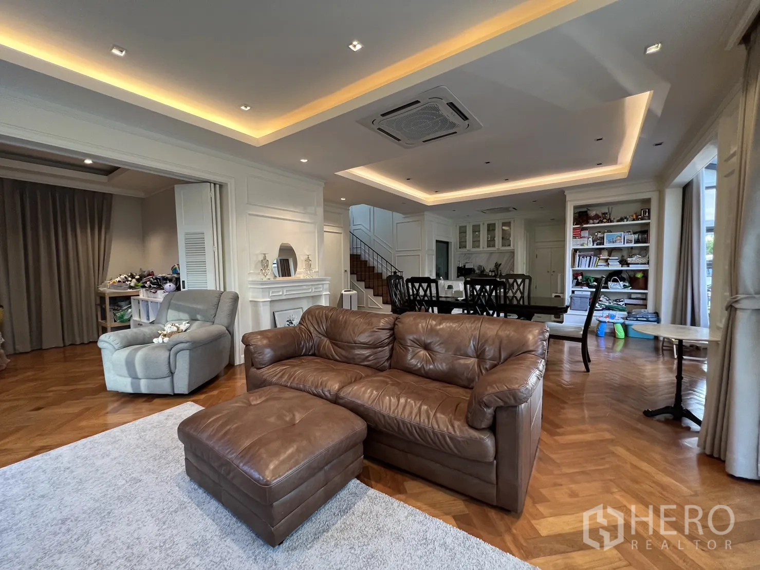 Detached House for rent in Suan Luang, Bangkok - Spacious living and dining zone with recessed lighting and leather sofa.
