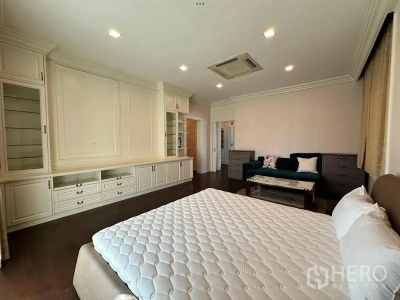 Detached House for rent or sale - Master bedroom with large bed, wall-to-wall built-in cabinets and seating area.