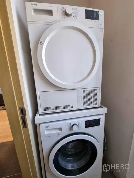 Condominium for rent in Watthana, Bangkok - Stacked washer and dryer set in a compact laundry nook.