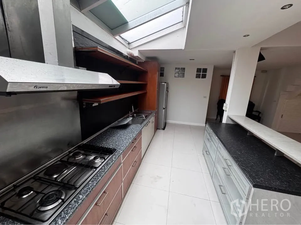 ทาวน์เฮาส์ for rent in Huai Khwang, Bangkok - ห้องครัวยาวพร้อมเคาน์เตอร์ เตาแก๊ส เครื่องดูดควัน และสกายไลท์.
