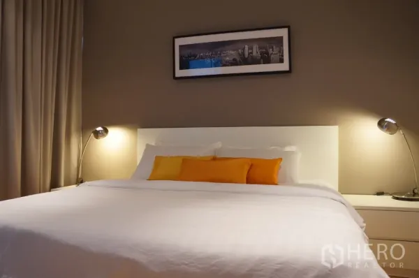 คอนโด ให้เช่าในRatchathewi, Bangkok - ห้องนอนอบอุ่น เตียงคิงไซส์ โคมไฟหัวเตียง และรูปเมืองบนผนัง