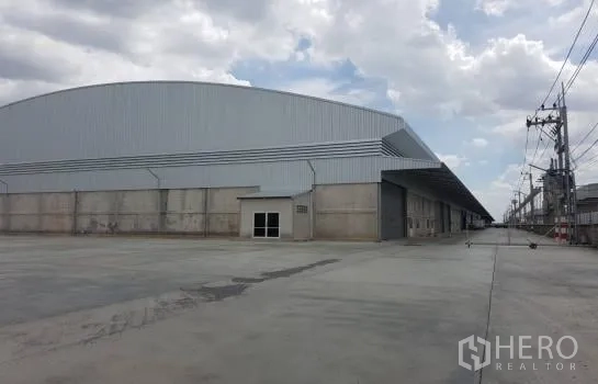 คลังสินค้า ให้เช่าในLam Luk Ka, Pathum Thani - มุมมองอาคารโกดังขนาดใหญ่พร้อมลานคอนกรีตกว้าง