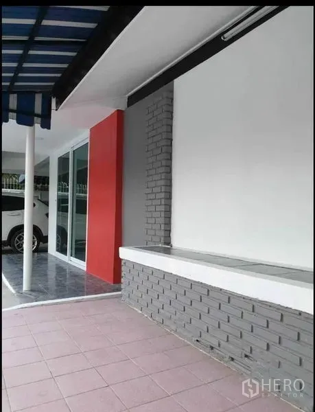 บ้าน ให้เช่าในLat Phrao, Bangkok - ชานบ้านทางเข้า มีกันสาดลายทาง ผนังสีแดง ประตูกระจกบานเลื่อน และพื้นกระเบื้อง