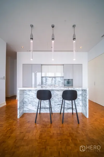 公寓 出租在Bang Rak, Bangkok - 现代大理石中岛厨房，三盏吊灯与两把吧椅。