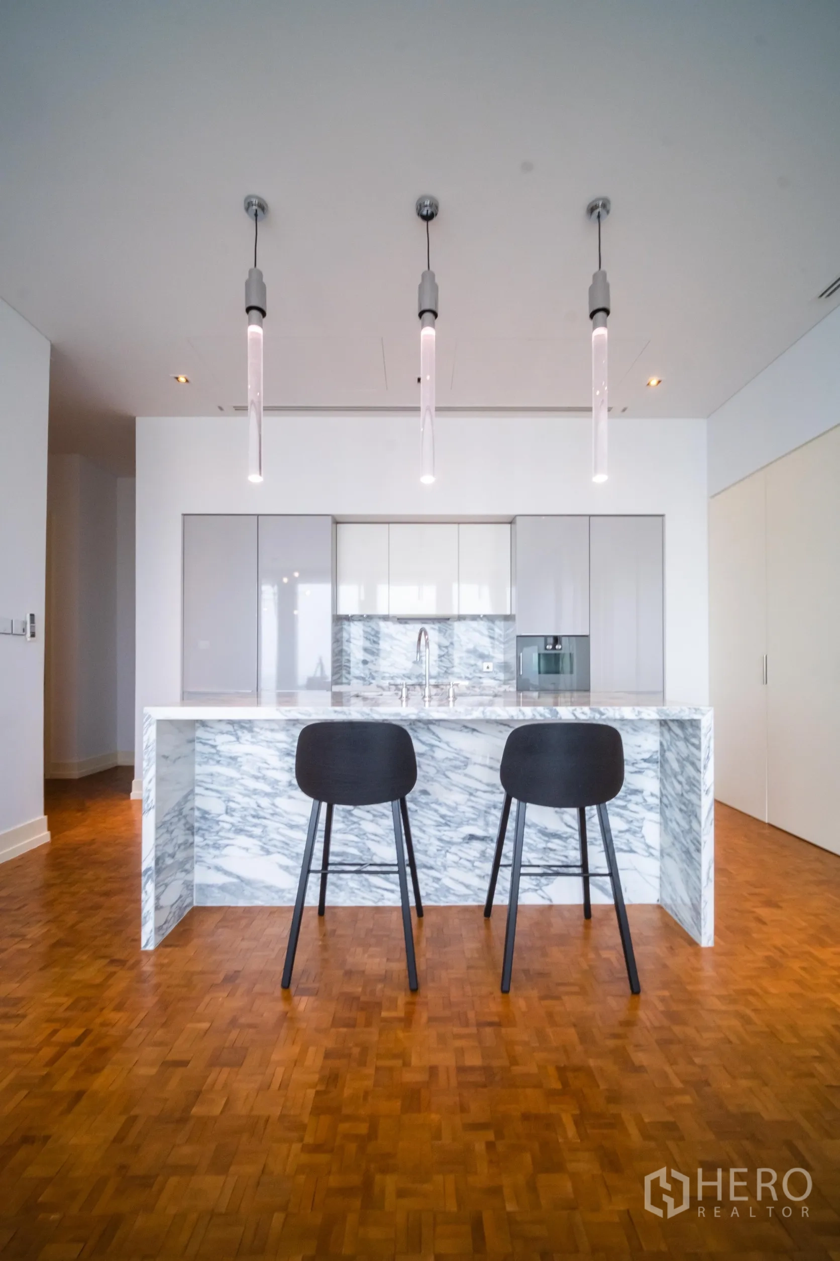 公寓 出租在Bang Rak, Bangkok - 现代大理石中岛厨房，三盏吊灯与两把吧椅。