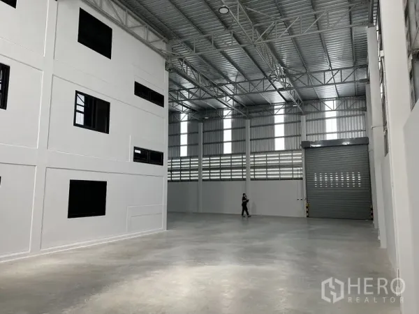 คลังสินค้า ให้เช่าในBang Phli, Samut Prakan - โถงเก็บสินค้าแสงสว่างดี มีสกายไลต์แนวตั้งและประตูม้วนสูงสำหรับรถบรรทุก