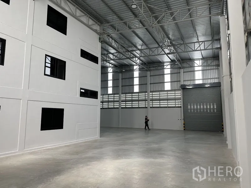 คลังสินค้า ให้เช่าในBang Phli, Samut Prakan - โถงเก็บสินค้าแสงสว่างดี มีสกายไลต์แนวตั้งและประตูม้วนสูงสำหรับรถบรรทุก