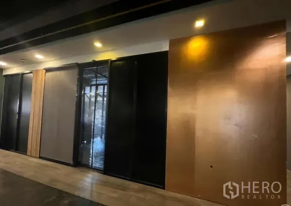 零售空间 出租在Watthana, Bangkok - 室内墙面采用深色推拉面板与嵌入式射灯。