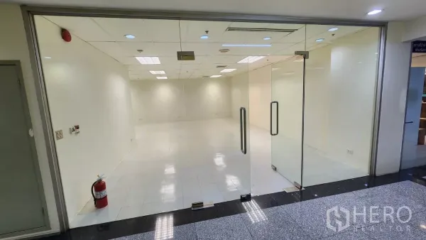 สำนักงาน ให้เช่าในWatthana, Bangkok - พื้นที่สำนักงานโอเพ่นแปลนขนาด 76 ตร.ม. พร้อมประตูกระจกบานคู่ พื้นกระเบื้องสีขาว และถังดับเพลิงบริเวณหน้าเข้า