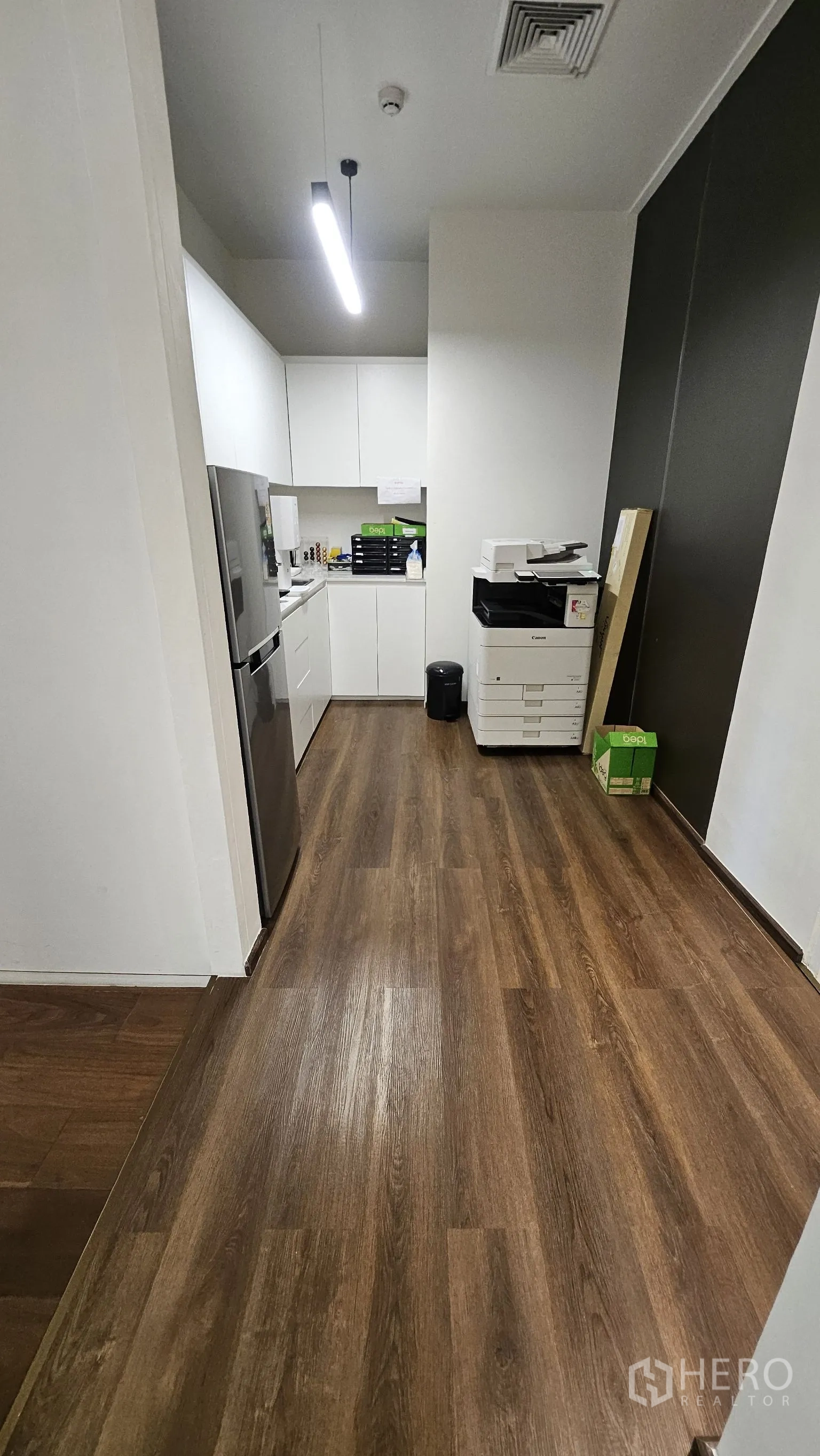 ออฟฟิศ for rent in Watthana, Bangkok - แพนทรีพนักงานพร้อมตู้เก็บของสีขาว ซิงก์ ตู้เย็น และเครื่องถ่ายเอกสารบนพื้นลายไม้.