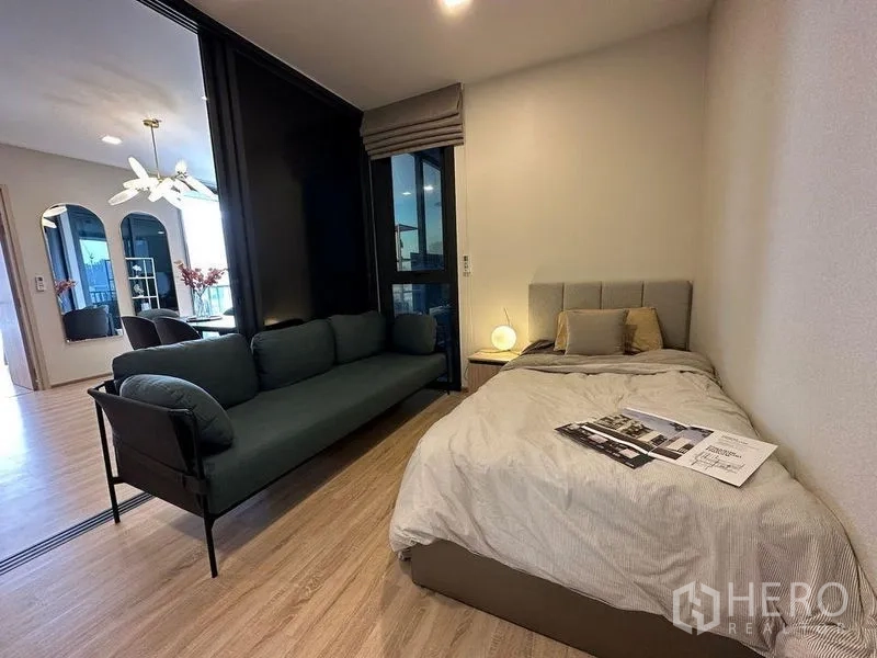 公寓 出租在Ratchathewi, Bangkok - 次卧配单人床与沙发，滑动玻璃隔断连通客厅。