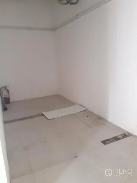 零售空间 出租在Watthana, Bangkok - 小型储物/设备间，白墙并配有灭火器。