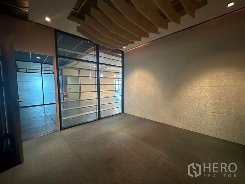 Office Space for rent in Khlong Toei, Bangkok - View of meeting room with glass door and slatted divider opening to common area.