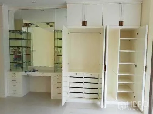 Townhouse for rent in Khlong Toei, Bangkok - Bedroom built-in white wardrobes with mirrored dressing table and shelves.