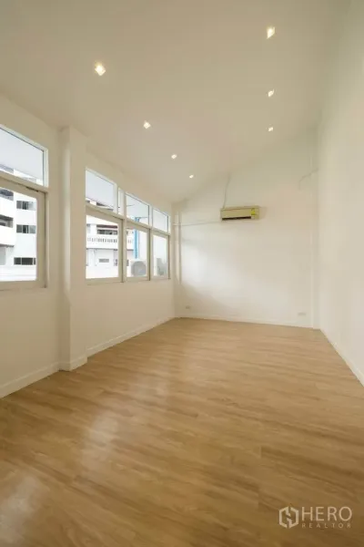 联排别墅 出租在Khlong Toei, Bangkok - 楼上宽敞房间，挑高天花与筒灯，多扇窗户引入自然采光。