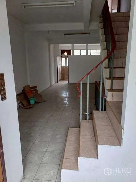 Shophouse for rent in Pom Prap Sattru Phai, Bangkok - Ground-floor interior with tiled floor and a central staircase, ideal for retail or reception.