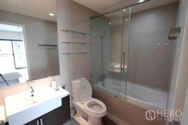 คอนโด ให้เช่าในKhlong Toei, Bangkok - ห้องน้ำสมัยใหม่ อ่างล้างหน้าโต๊ะกว้าง โถสุขภัณฑ์ และอ่างอาบน้ำพร้อมฉากกั้นกระจก.