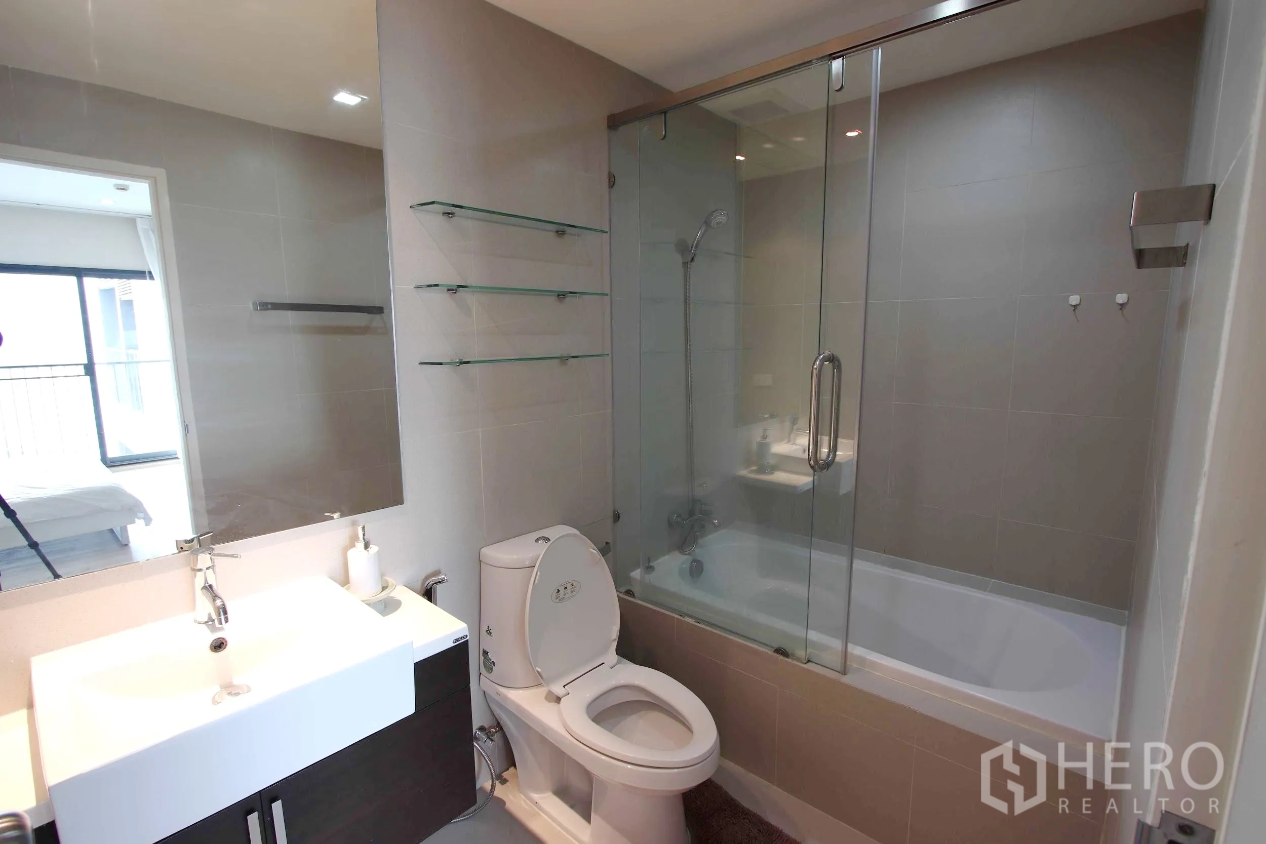 คอนโด ให้เช่าในKhlong Toei, Bangkok - ห้องน้ำสมัยใหม่ อ่างล้างหน้าโต๊ะกว้าง โถสุขภัณฑ์ และอ่างอาบน้ำพร้อมฉากกั้นกระจก.