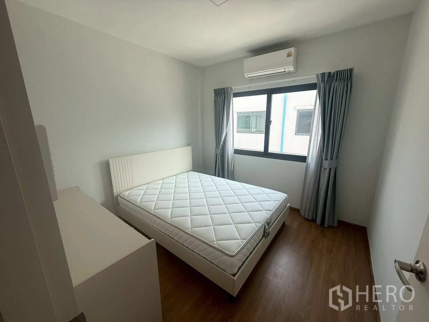 Townhouse for rent in Bang Phli, Samut Prakan - Bright bedroom with bed, curtains and air conditioner.