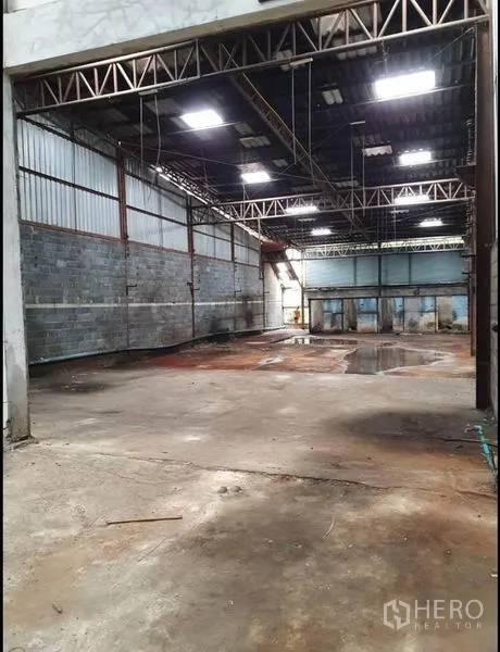 Warehouse for rent in Phra Samut Chedi, Samut Prakan - Spacious warehouse bay with steel truss roof, skylight panels and durable concrete floor.