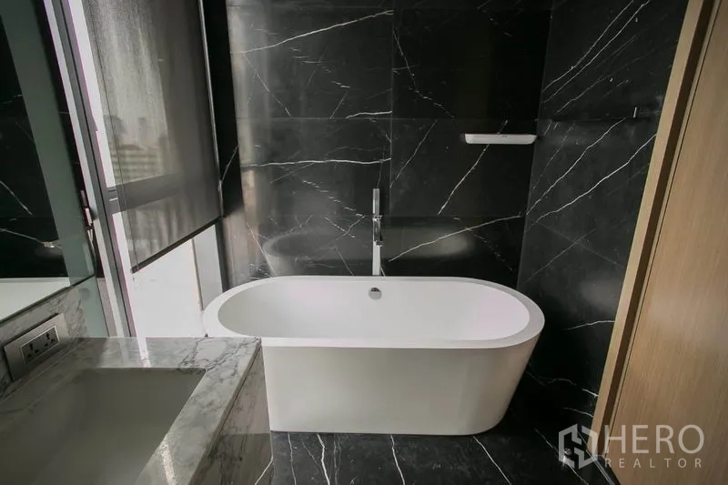 公寓 出租或出售在Watthana, Bangkok - 卫浴设独立浴缸，黑色大理石背景墙，临窗采光。