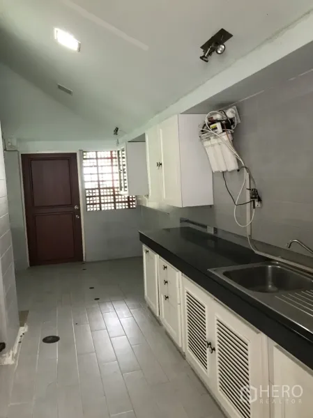 บ้าน ให้เช่าในLat Krabang, Bangkok - ครัวแบบแกลเลย์ ตู้สีขาว เคาน์เตอร์ท็อปสีดำ อ่างล้างจานสแตนเลส ผนังกระเบื้องสีเทา