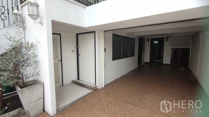 Home Office for rent in Watthana, Bangkok - Covered driveway and entrance corridor beneath the upper balcony.