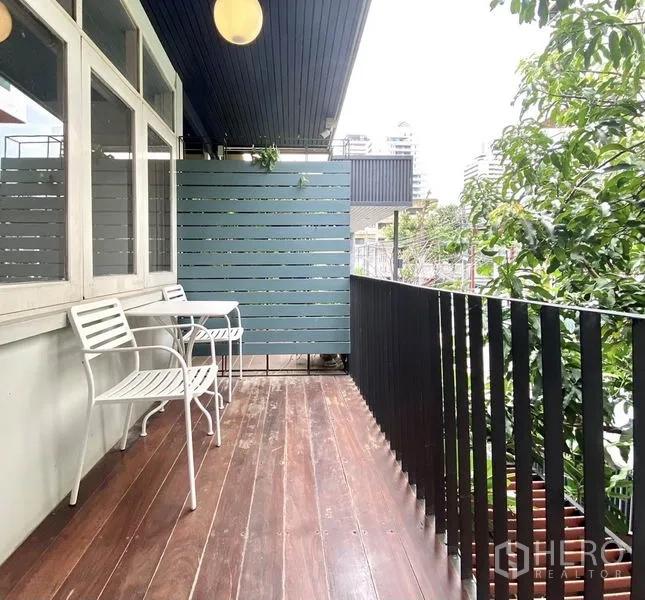 ทาวน์เฮาส์ ให้เช่าในKhlong Toei, Bangkok - ระเบียงชั้นบนพื้นไม้ ราวเหล็ก พร้อมเก้าอี้นั่ง มองเห็นต้นไม้