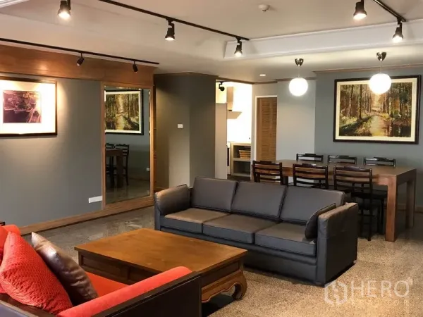 คอนโด ขายในWatthana, Bangkok - ห้องนั่งเล่นและรับประทานอาหารแบบโอเพ่นแปลน โซฟาสีเทา โต๊ะไม้ ไฟราง กระจกบานใหญ่ ในคอนโดเขตวัฒนา