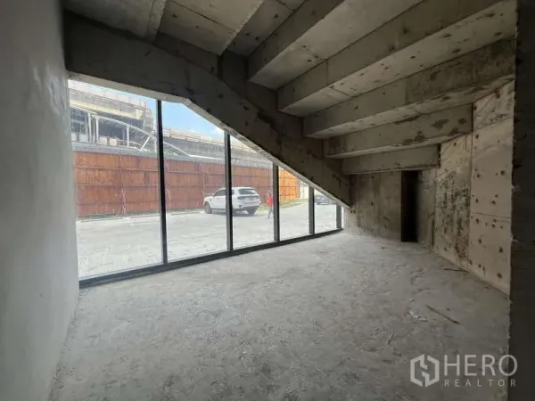 零售空间 出租 - 临街零售毛坯空间，落地玻璃门面与斜顶下的清水混凝土