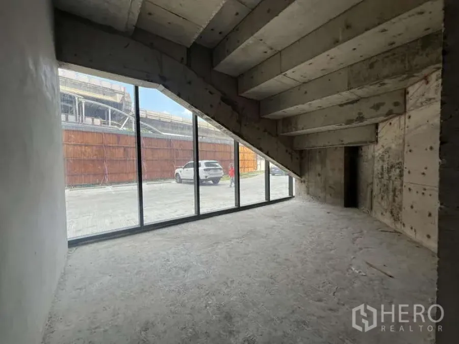 零售空间 出租 - 临街零售毛坯空间，落地玻璃门面与斜顶下的清水混凝土