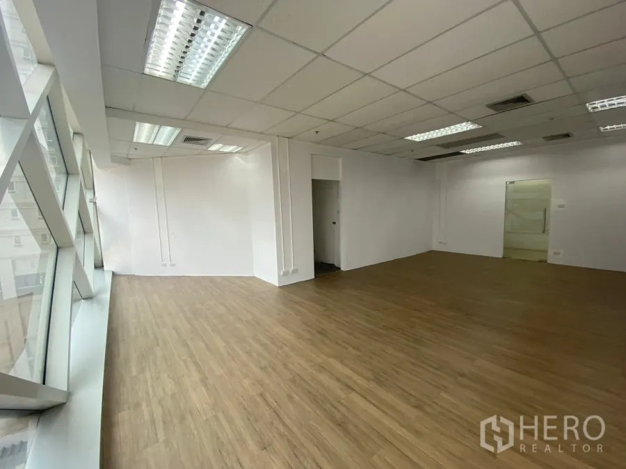 สำนักงาน ให้เช่าในWatthana, Bangkok - ภายในสำนักงานโล่ง มีประตูกระจก ผนังสีขาว พื้นลายไม้ และหน้าต่างกระจกเต็มความสูง