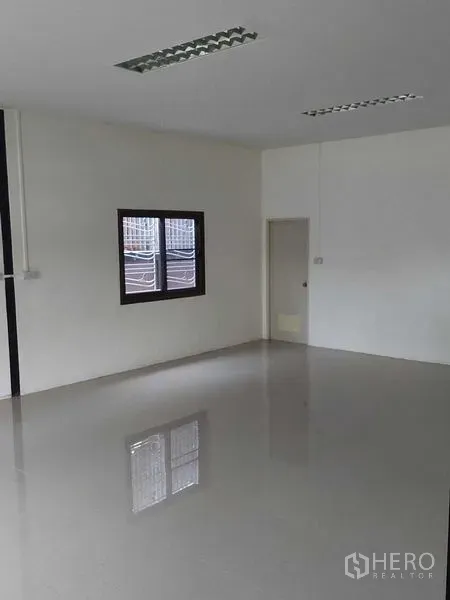 货栈 出租在Pathum Thani - 仓库内洁净办公室，亮面地砖、窗户与吊顶照明。