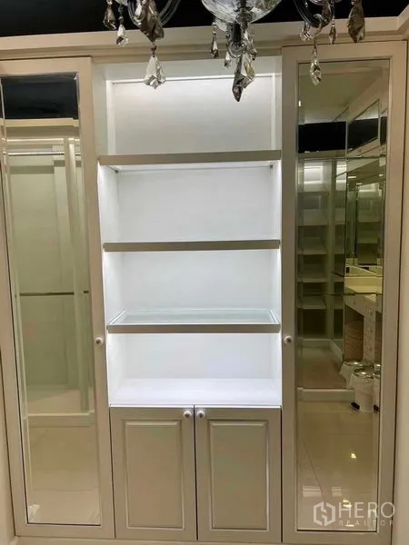 公寓 出售在Bang Na, Bangkok - 带照明的嵌入式层架与镜面衣柜门，顶部水晶灯。