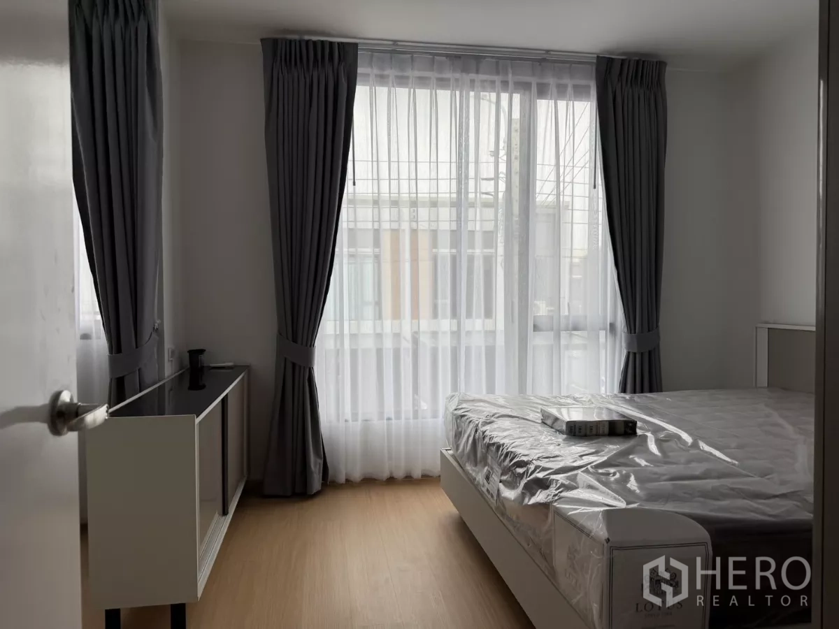 Townhouse for rent in Bang Phli, Samut Prakan - Secondary bedroom with large windows, sheer curtains and a bed.