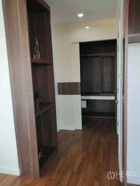 公寓 出售在Yan Nawa, Bangkok - 走廊处的深色木质衣柜与置物架。